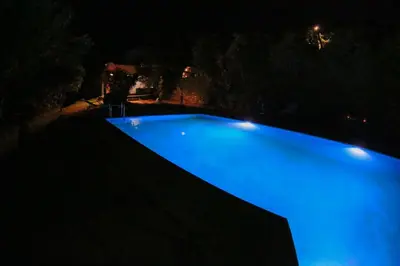 a large blue swimming pool at night with lights at Elafonisi Manor with Private Pool & Jaccuzi in Perivólia