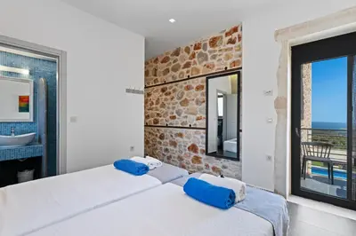 a bedroom with a large bed with a view of the ocean at Villa Enid in Sinoikismós Mamounianá