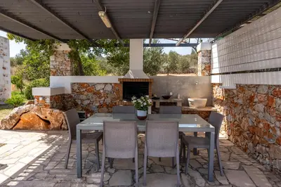a table and chairs on a patio with a fireplace at Villa Resi in Vamos