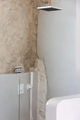 a bathroom with a white cabinet and a wall at Hub Hospitality in Chania Town