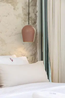 a bedroom with a bed and a pendant light at Hub Hospitality in Chania Town