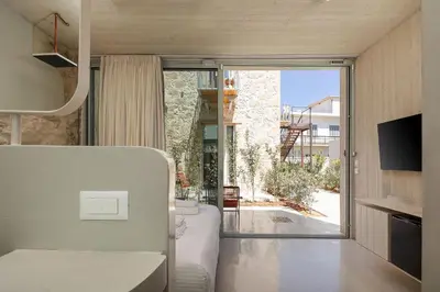 a room with a bed and a sliding glass door at Hub Hospitality in Chania Town