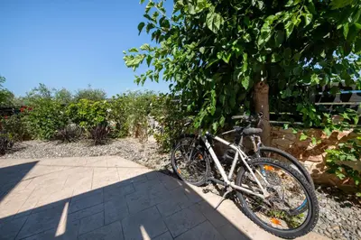 a bike parked under a tree on a sidewalk at Villa Lady Dafni with private heated pool in Maleme