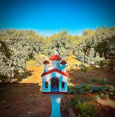 a small building in the middle of a garden at Mersini Village in Milonianá