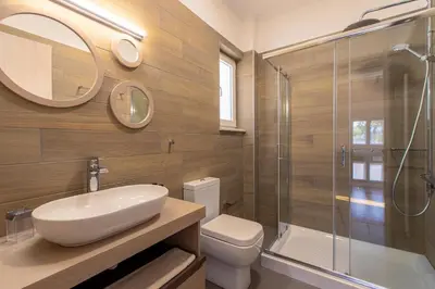 a bathroom with a sink and a toilet and a shower at Mystique Villa by Vintage Travel in Tavronitis