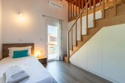 a bedroom with a bed and a staircase at Mystique Villa by Vintage Travel in Tavronitis