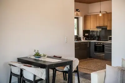a kitchen with a table and chairs in a room at Myrtia Beach House in Tersanas