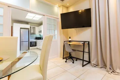 a dining room with a glass table and a television at Harbour - Spacious Unique 2-Balcony Apartment in Chania Old Town in Chania Town