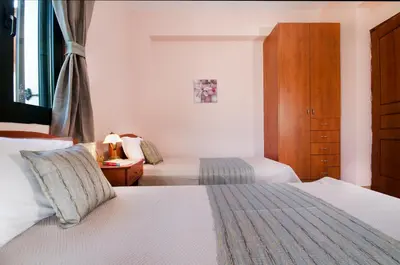 a hotel room with two beds and a window at Villa Alimedon in Almirida