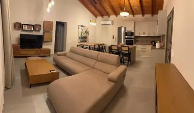 a large living room with a couch and a kitchen at Matthew's house in Kalamítsion Alexándrou