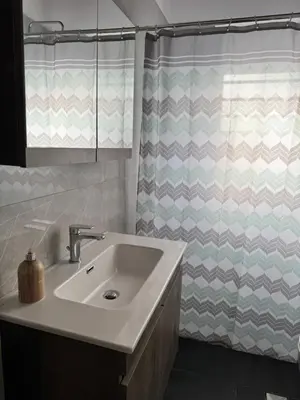 a bathroom with a sink and a shower curtain at Matthew's house in Kalamítsion Alexándrou