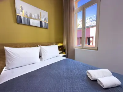 a bedroom with a bed with two towels on it at Deluxe Center Suites in Chania Town
