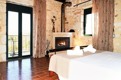 a bedroom with a bed and a fireplace at Chania's Diamond Villas - Aqua Bliss with Private Pools in Gavalochori