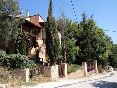 a house with a fence in front of a street at Apartment in natural stone house in Spiliá