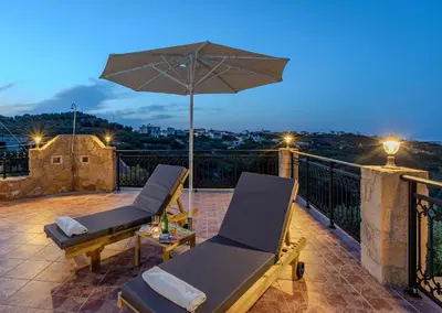 a patio with two lounge chairs and an umbrella at Anna by Vintage Travel in Troúlous