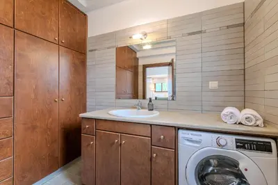 a bathroom with a washing machine and a sink at Anna by Vintage Travel in Troúlous