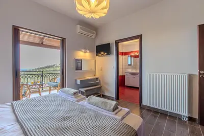a bedroom with a bed and a balcony at Anna by Vintage Travel in Troúlous