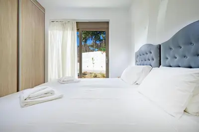 a bedroom with a large white bed with a blue headboard at Villa Sea Breeze in Xamoudhokhórion