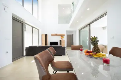 a dining room with a table with a bowl of fruit at Villa Sea Breeze in Xamoudhokhórion