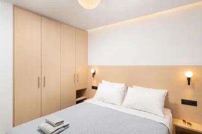 a bedroom with a white bed with white pillows at Ethea Residences-Helia in Chania Town