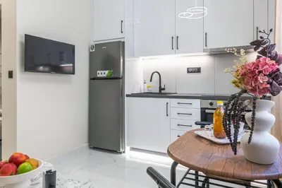 a kitchen with a table with a vase of flowers at Peonia Apartment Modern Two-Level Stay Near Old Town in Chania Town