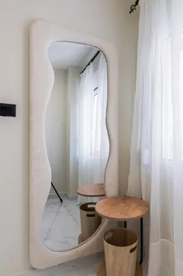 a mirror in a room with a table and two tables at Peonia Apartment Modern Two-Level Stay Near Old Town in Chania Town