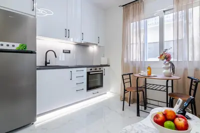 a kitchen with a table with a bowl of fruit at Peonia Apartment Modern Two-Level Stay Near Old Town in Chania Town