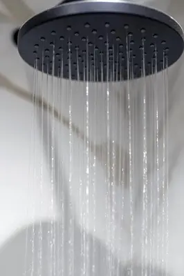 a shower with water dripping from a black shower head at Peonia Apartment Modern Two-Level Stay Near Old Town in Chania Town