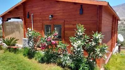 a wooden cabin with flowers in front of it at La Irilia Residences & Retreat in Agios Padeleimon