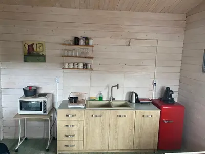 a kitchen with a sink and a microwave and a red refrigerator at La Irilia Residences & Retreat in Agios Padeleimon