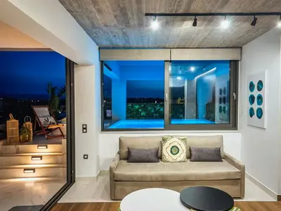 a living room with a couch and a large window at Amazing views in Chania Town