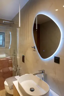 a bathroom with a sink and a toilet and a mirror at Lumera Urban Stay - New 2BR Home with Private Parking near Old Town in Chania Town