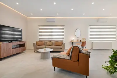 a living room with a couch and a tv at Coralie 3 bedroom apartment 40m from the beach in Chania Town