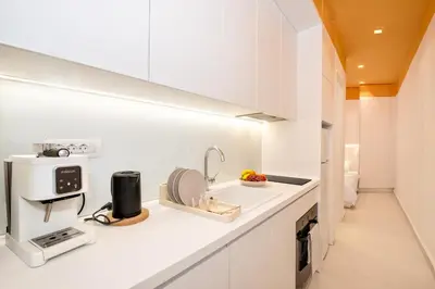 a white kitchen with a sink and a microwave at Athena Studio 1 in Chania Town