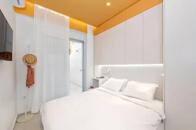 a bedroom with a white bed with an orange ceiling at Athena Studio 1 in Chania Town