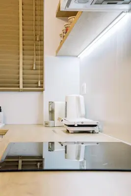 a kitchen with white cabinets and a sink at Terra Chic Retreat Suite in Chania Town