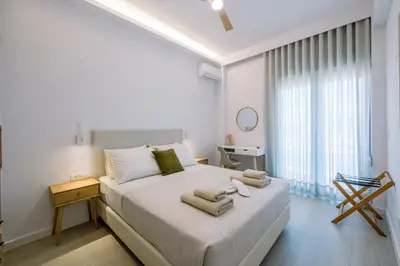 a white bedroom with a bed with towels on it at Terra Chic Retreat Suite in Chania Town