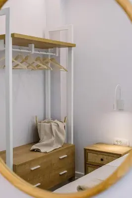 a mirror reflecting a bedroom with a bed and a dresser at Terra Chic Retreat Suite in Chania Town