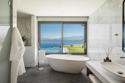 a bathroom with a tub and a view of the water at Only View Villa - Timeless Coastal Retreat by etouri in Chania