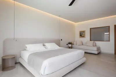 a white bedroom with a large bed and a couch at Only View Villa - Timeless Coastal Retreat by etouri in Chania