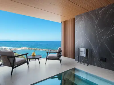a living room with a view of the ocean at Hilton Chania Old Town Resort & Spa in Chania Town
