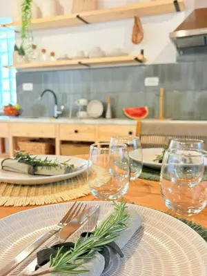 a table with plates and wine glasses on it at Athina's Cozy Guest House in Kamisianá