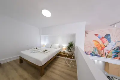 a bedroom with a bed and a painting on the wall at Hanim 2BR Loft Apartment - Garden & Indoor Parking in Chania Town