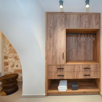 a wooden wardrobe in a room with a wall at Bōw Ground Floor Luxury Apt-In Chania Old Town! in Chania Town