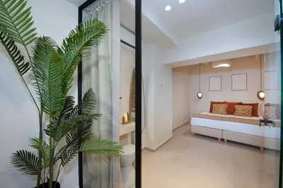 a bedroom with a bed and a plant in a room at BŌW 1st Floor Luxury Apt -Heart of Chania Old Town in Chania Town
