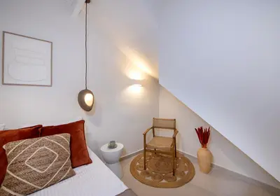 a bedroom with a bed and a chair at BŌW 1st Floor Luxury Apt -Heart of Chania Old Town in Chania Town