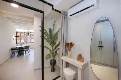 a bathroom with a mirror and a toilet and a table at BŌW 1st Floor Luxury Apt -Heart of Chania Old Town in Chania Town
