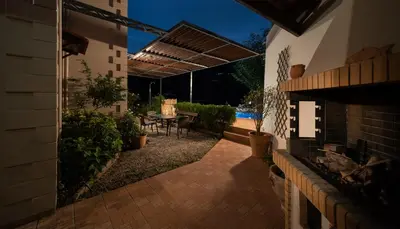 an outdoor patio with a table and a fireplace at Villa Eleni Meskla in Mesklá