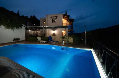 a swimming pool in front of a house at night at Villa Eleni Meskla in Mesklá