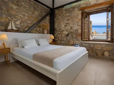 a bedroom with a large bed and a window at Omorphi Seaside Villa in Kalyves